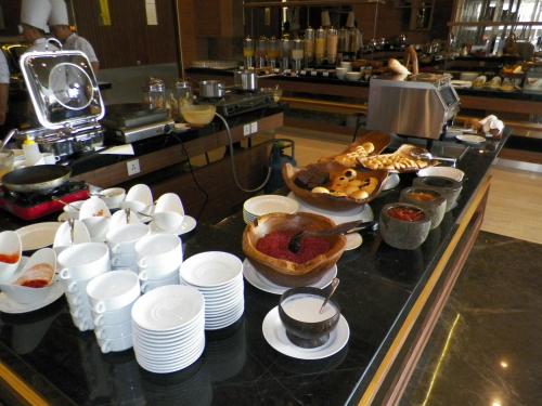 a buffet line with dishes and food on a counter at Harper Malioboro Yogyakarta by ASTON in Yogyakarta