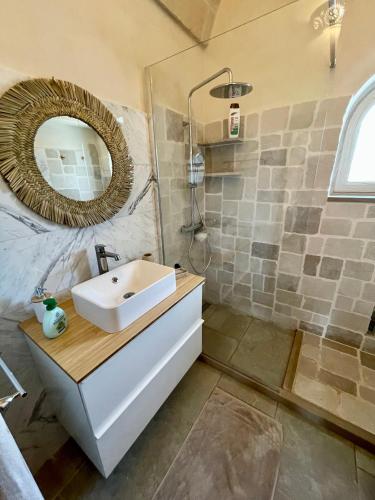 a bathroom with a sink and a mirror at Trullo Bubamare in San Michele Salentino