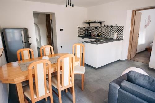 Štekner house Apartma في Ljubno: مطبخ وغرفة طعام مع طاولة وكراسي خشبية
