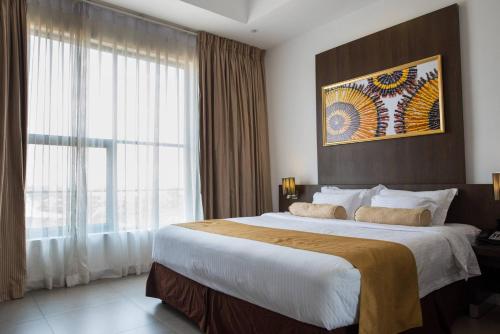 a bedroom with a large bed with a large window at Best Western Elyon Colombo in Colombo