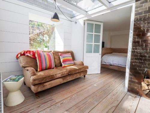 a living room with a couch and a bedroom at Apple Cottage in Cheltenham