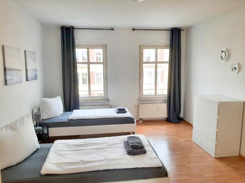 a room with two beds and two windows at Cozy 1 room apartment in Magdeburg in Magdeburg