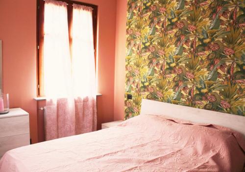 a bedroom with a bed with a floral wallpaper at Cascina Manzo in Dogliani