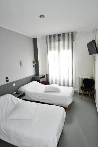 een hotelkamer met 2 bedden en een raam bij Le Pasteur in Brest