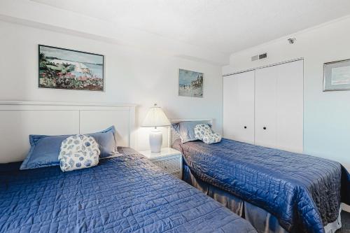 a bedroom with two beds with blue comforters at Plaza 1610 in Ocean City
