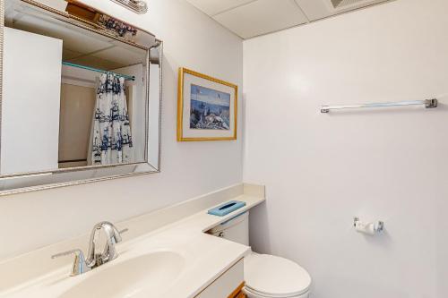 a white bathroom with a sink and a mirror at Plaza 1610 in Ocean City