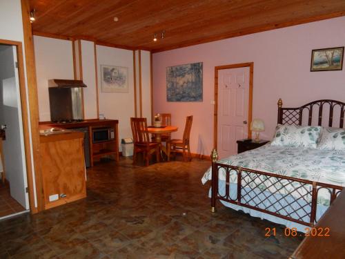 Schlafzimmer mit einem Bett, einem Tisch und Stühlen in der Unterkunft Self-contained Cabin 10 min to Huskisson in Tomerong