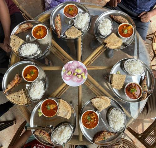 una mesa cubierta con muchos platos diferentes de comida en Paradise Point, en Ratnagiri