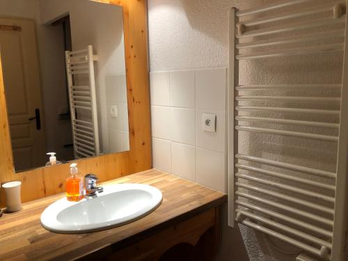 un bagno con lavandino e specchio di Bel appartement en résidence avec piscine a Orelle