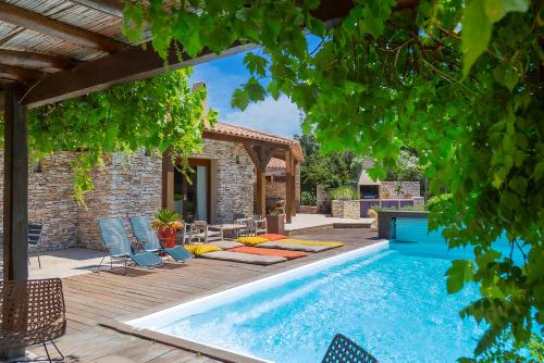 a pool in a backyard with chairs and a house at Les chambres SoleLuna Bonifacio in Bonifacio