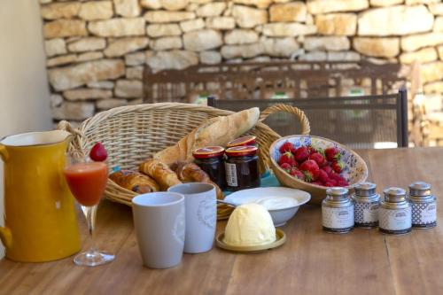 a table with a basket of bread and a basket of fruit at Les chambres SoleLuna Bonifacio in Bonifacio