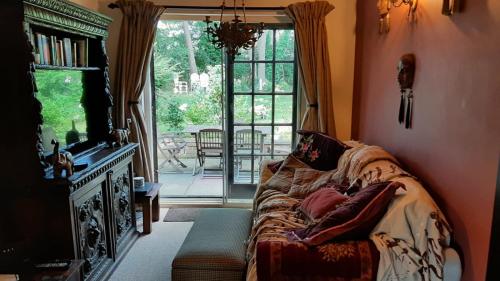 uma sala de estar com um sofá e uma grande janela em Quirky 18th Century Thatched Cottage em Great Staughton