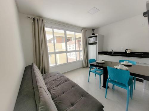 a living room with a couch and a table and chairs at Hospeda Mariscal Flat in Bombinhas