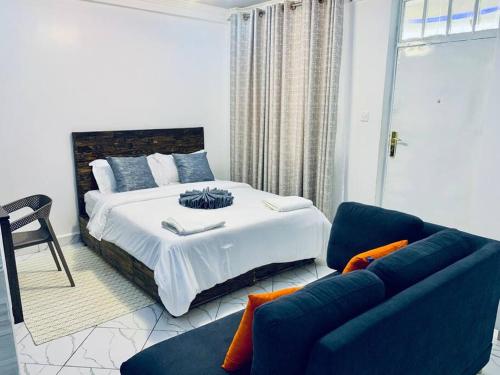 ナニュキにあるArabel Studio Apartmentのベッドと青いソファのある寝室