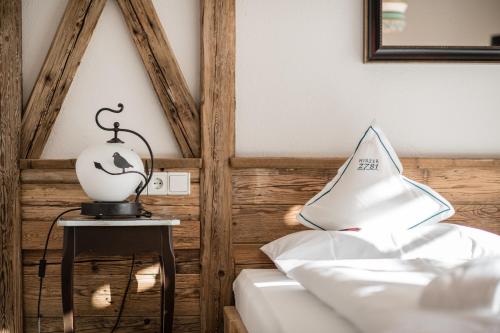 a room with a lamp on a table next to a bed at Hotel Hirzer 2781 in Avelengo