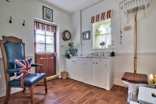 a bathroom with a sink and a chair in a room at Wellbrook Place by Group Retreats in Heathfield