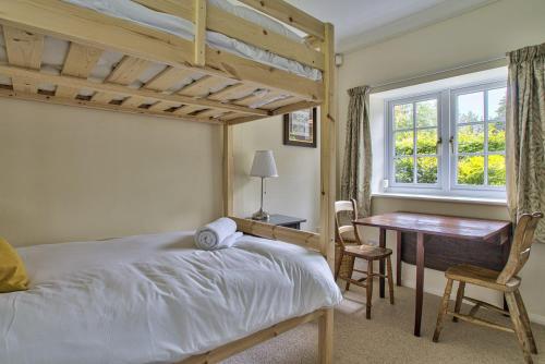 a bedroom with a bed and a desk and a window at Wellbrook Place by Group Retreats in Heathfield