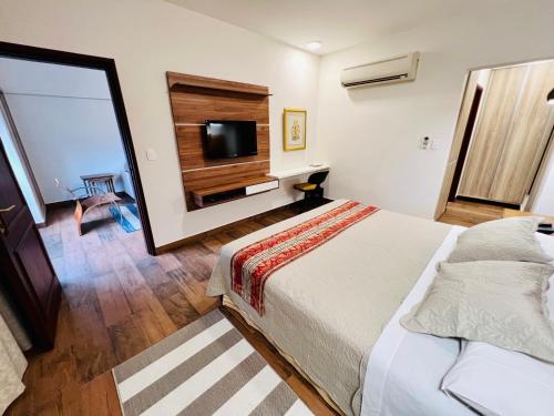 a bedroom with a bed and a flat screen tv at Sabe Center in Asuncion