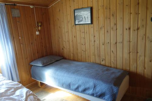 a bedroom with a bed in a wooden wall at Høvringen Fjellstue in Høvringen