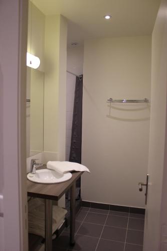 une salle de bain avec un lavabo et un miroir dans l'établissement Tour Eiffel Grenelle, à Paris