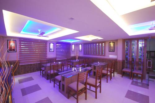 a restaurant with wooden tables and chairs and purple ceilings at North Centre in Cochin