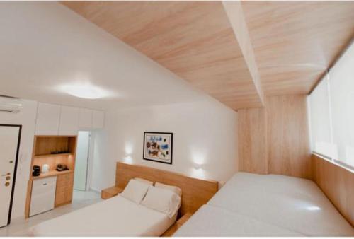 um quarto com uma cama branca e um tecto de madeira em Luxury Studio in the heart of Kolonaki em Atenas