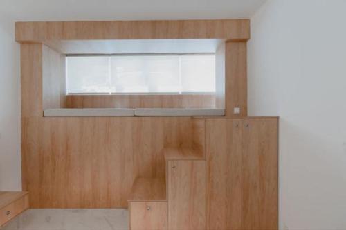 um quarto com uma janela e uma parede de madeira em Luxury Studio in the heart of Kolonaki em Atenas