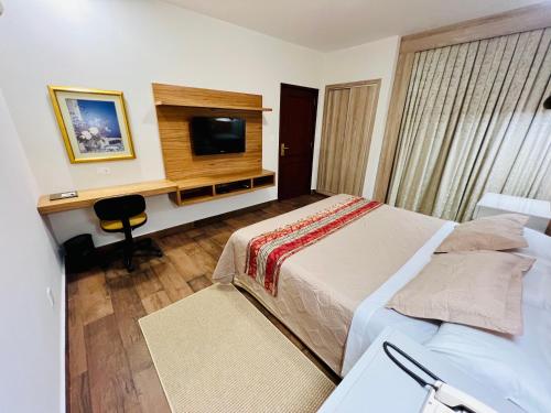 a bedroom with a bed and a desk and a television at Sabe Center in Asuncion