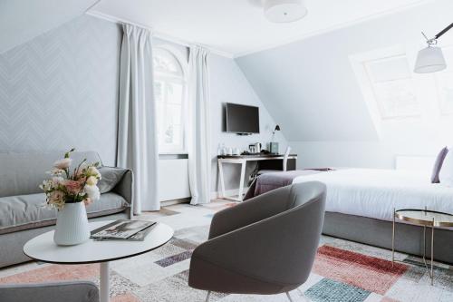 a bedroom with a bed and a couch and a table at Pałac Łebunia in Łebunia