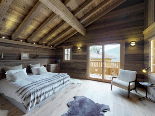 ein Schlafzimmer mit großem Bett und Holzdecke in der Unterkunft Chalet raffiné à La Tania, Courchevel - 10/12 pers, spa, sauna, billard, ski-in/ski-out - FR-1-575-20 in Courchevel