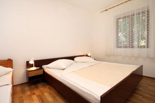 - une chambre avec un grand lit et une fenêtre dans l'établissement Apartments by the sea Mudri Dolac, Hvar - 118, à Vrboska