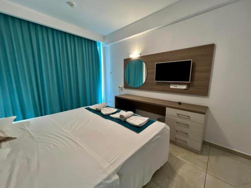a hotel room with a bed and a tv at Sunny Blue Hotel in Ayia Napa