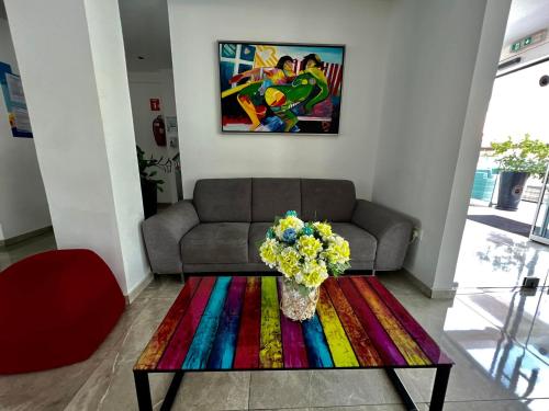 a living room with a couch and a table with a colorful rug at Sunny Blue Hotel in Ayia Napa