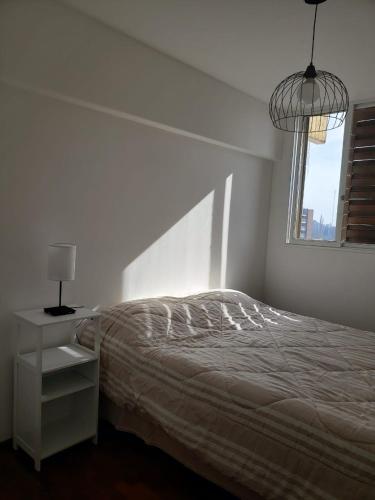 Habitación blanca con cama y ventana en LA ESQUINA en Mendoza
