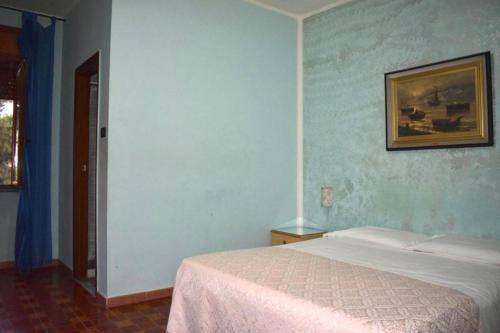 a bedroom with a bed and a picture on the wall at Hotel Belvedere in Ercolano