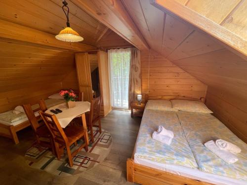 a room with two beds and a table in a cabin at Pienińska Willa Aleksandrówka in Szczawnica