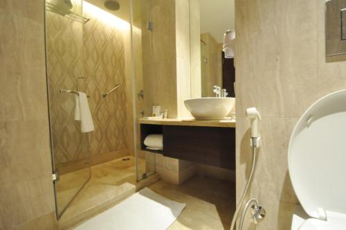 a bathroom with a sink and a glass shower at Hotel Marigold Jaipur in Jaipur