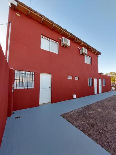 ベジャ・ビスタにあるLas Ruinasの白いドアと窓の赤い建物