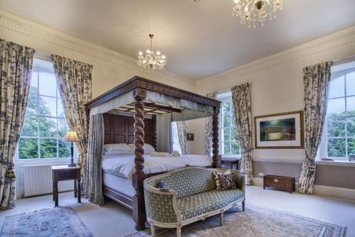 a bedroom with a canopy bed and a chair at The Castle By Group Retreats in Hartlepool