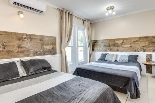 1 dormitorio con 2 camas y ventana en Le Saint Alex, en Saint-Alexis-des-Monts
