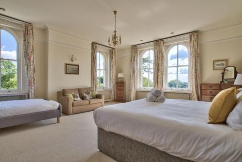 a large bedroom with two beds and windows at Milton House Group Retreats in Bedford