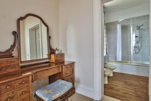 a bathroom with a sink and a mirror and a toilet at Milton House Group Retreats in Bedford