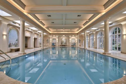 a swimming pool in a large building with columns at Fawley Court by Group Retreats in Hereford