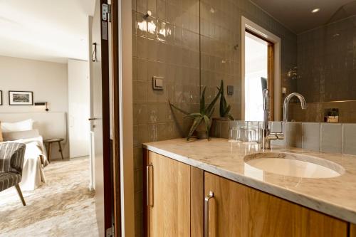 a bathroom with a sink and a large mirror at Slottsholmen Hotell och Restaurang in Västervik