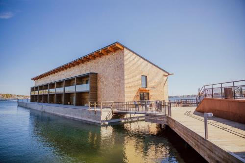 a building on a dock next to the water at Slottsholmen Hotell och Restaurang in Västervik