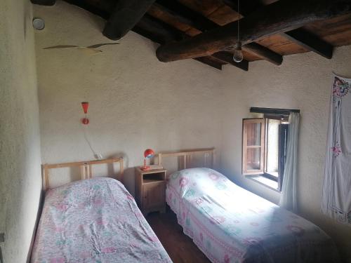 a bedroom with two beds and a window at La casa del pozzo in Sillico