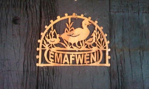 un panneau en bois sur une porte en bois avec un istg de poule dans l'établissement Emafweni, à Champagne Valley