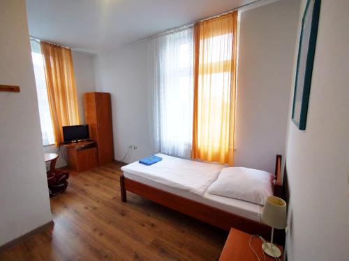 a small bedroom with a bed and a window at Hotel Stary Ratusz in Kostomłoty