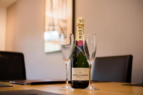 a bottle of wine and two glasses on a table at The Galleries No 3 in Spean Bridge