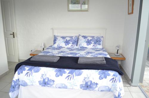 a bed with blue and white sheets and pillows at 24 on Karee in Stilbaai
